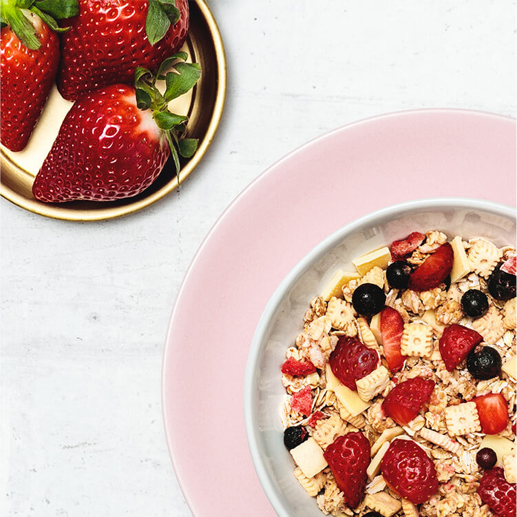 Frische Erdbeeren und eine Müsli Schüssel gefüllt mit Strawberry Cheesecake Müsli