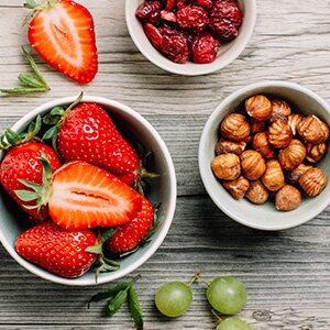 In die Smoothiebowl kommen Erdbeeren, Mandelmilch und Nüsse